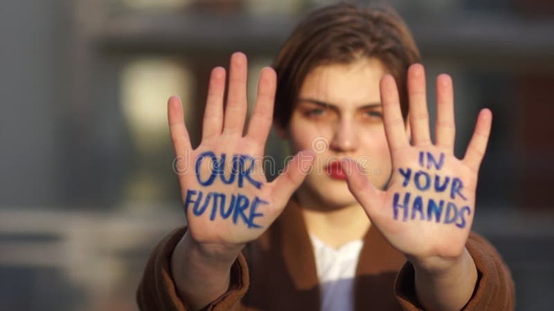 Young woman protests against global warming. Climatic strike, environmental disaster. Close portrait of a beautiful