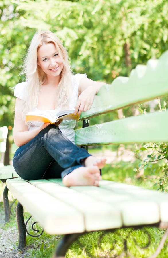 Young woman reading book in park