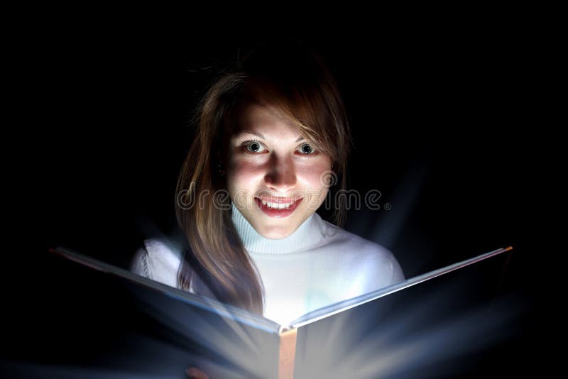 Young woman reading a magic book