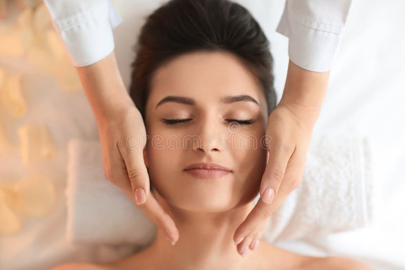 Young Woman Receiving Face Massage In Spa Salon Top View Stock Image