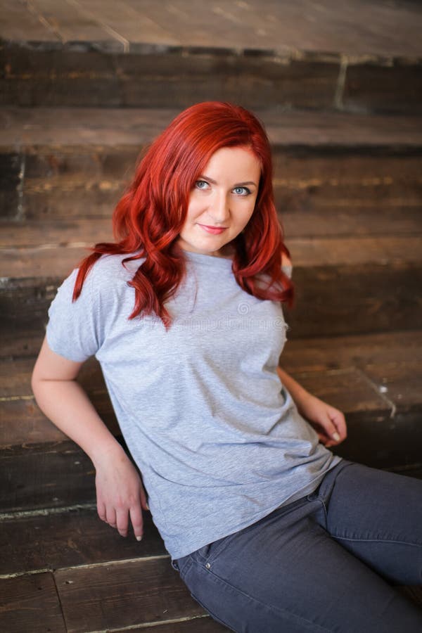 Young woman with red long hair indoor portrait on wooden background stock photos Young woman with red long hair indoor portrait on wooden background stock photos