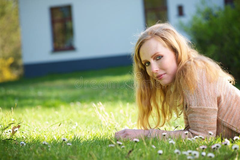 Young woman relaxing on grass outdoors