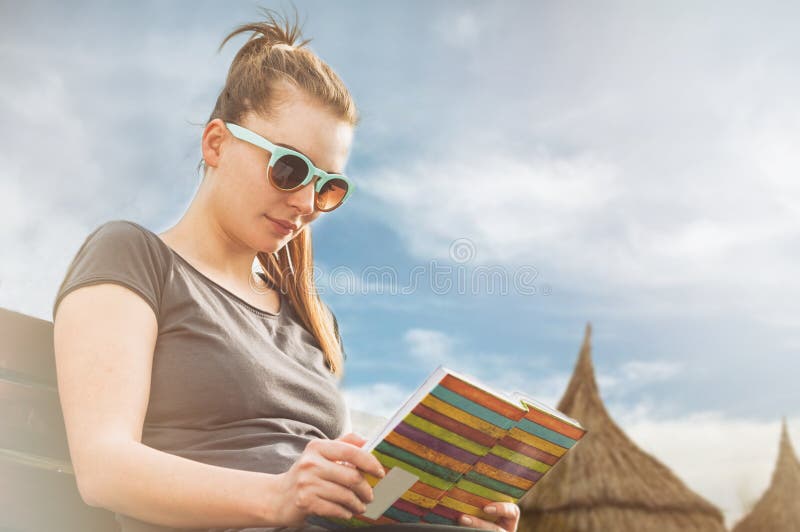 Young woman relaxing and reading a book on sunny day stock image Young woman relaxing and reading a book on sunny day stock image