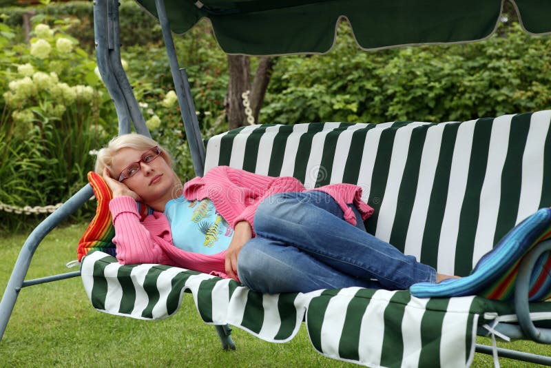 Young woman resting in a garden chair