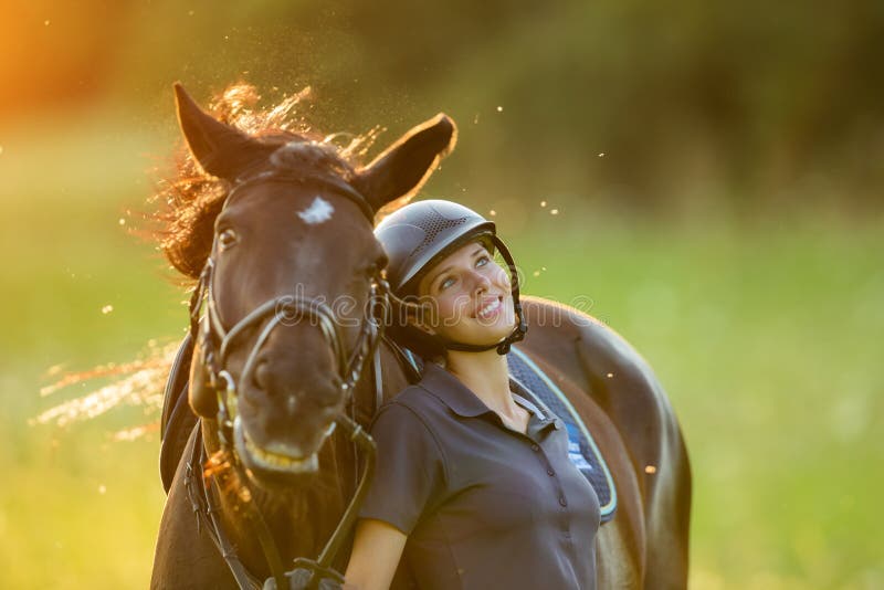 Young woman rider with her horse enjoying good mood stock photography Young woman rider with her horse enjoying good mood stock photography