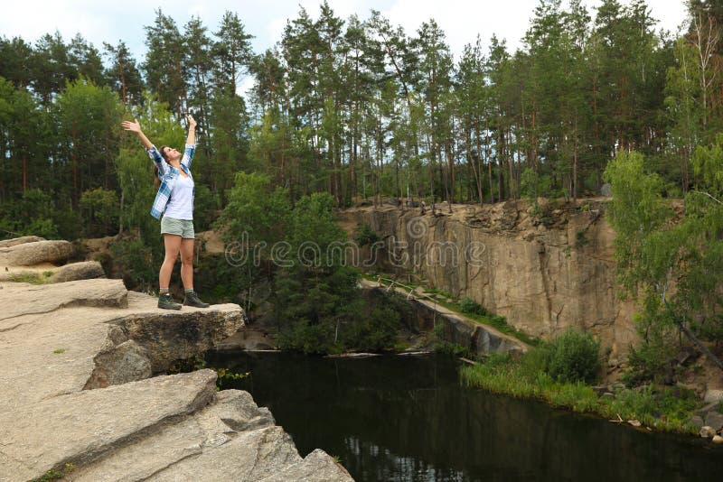 Young woman on rocky mountain near lake