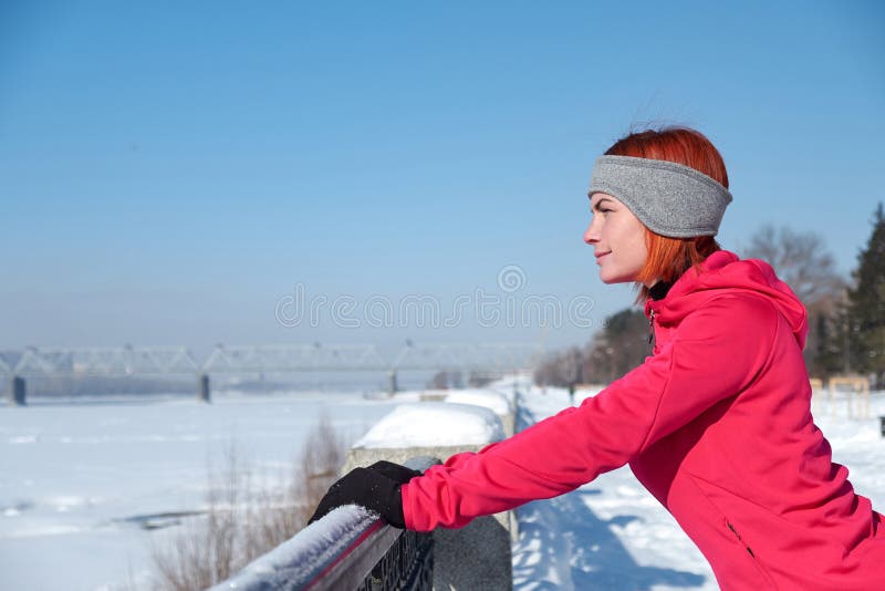 young woman after run rests on waterfront and looks into distance royalty free stock image young woman after run rests on waterfront and looks into distance royalty free stock image