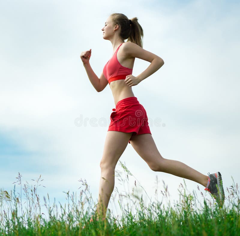 Beautiful fit woman fitness exercises outdoors. Stock Photo by