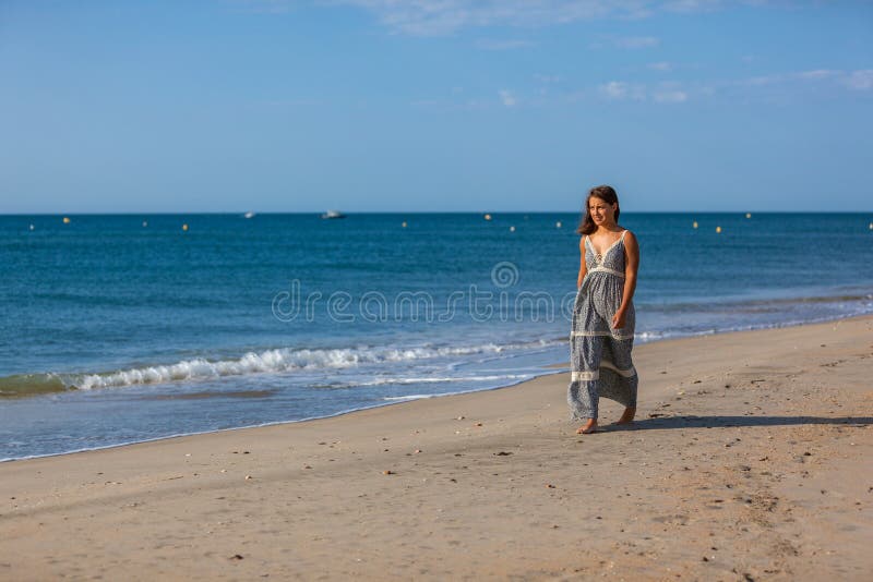 YOUNG WOMAN on the SAND of the BEACH Stock Image image
