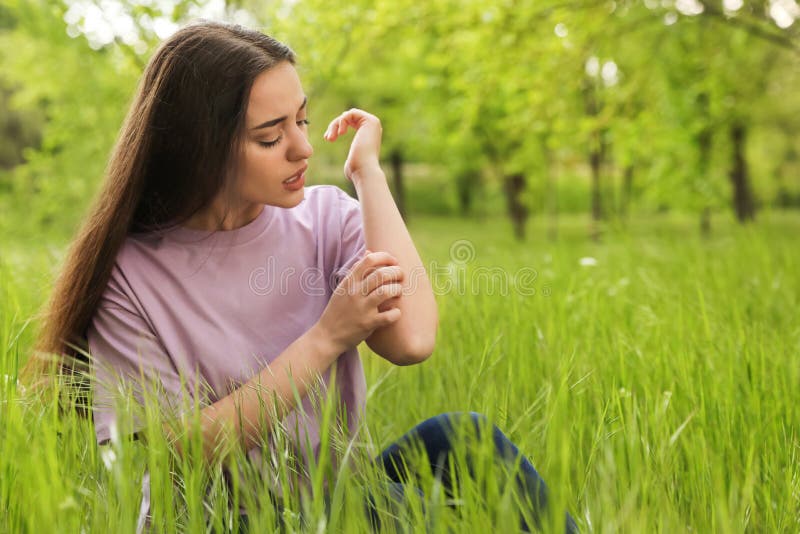 Young woman scratching hand outdoors. Seasonal allergy stock image Young woman scratching hand outdoors. Seasonal allergy stock image