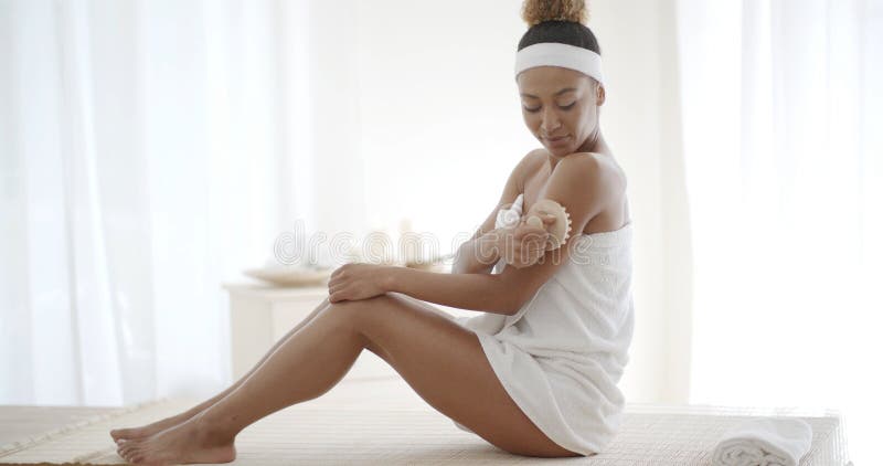 Young Woman Scrubbing Her Leg stock image Young Woman Scrubbing Her Leg stock image