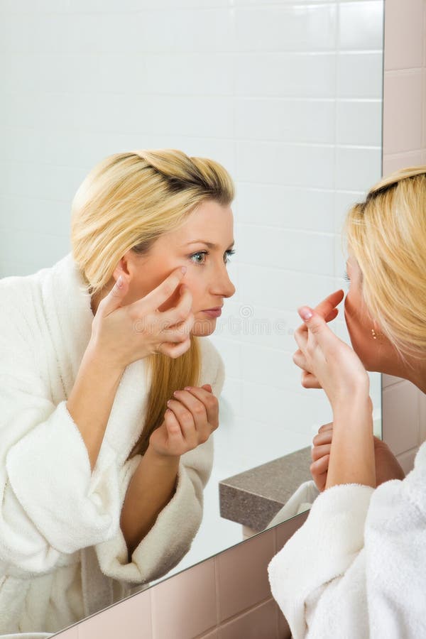 Young Woman searching for wrinkles on her face