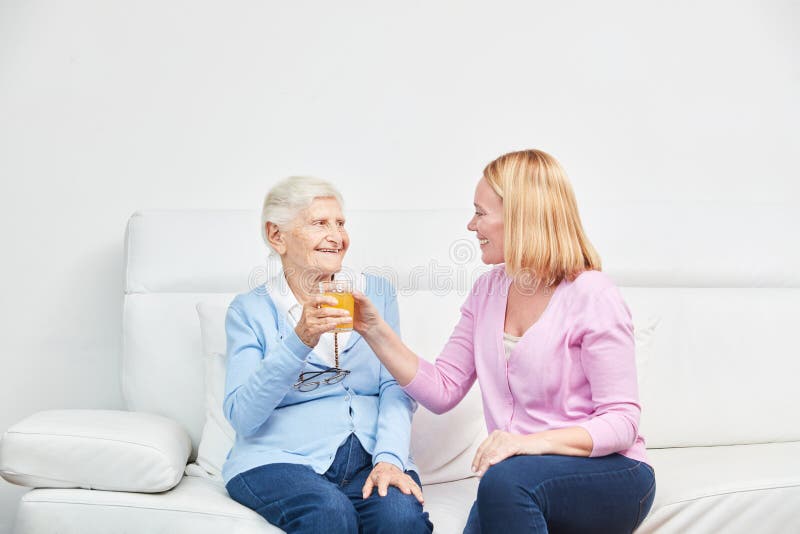 Young woman and senior woman drink juice together stock photos Young woman and senior woman drink juice together stock photos
