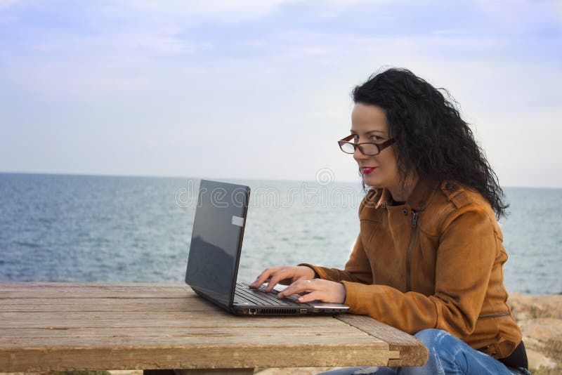 Young woman on shore with computer. stock image Young woman on shore with computer. stock image