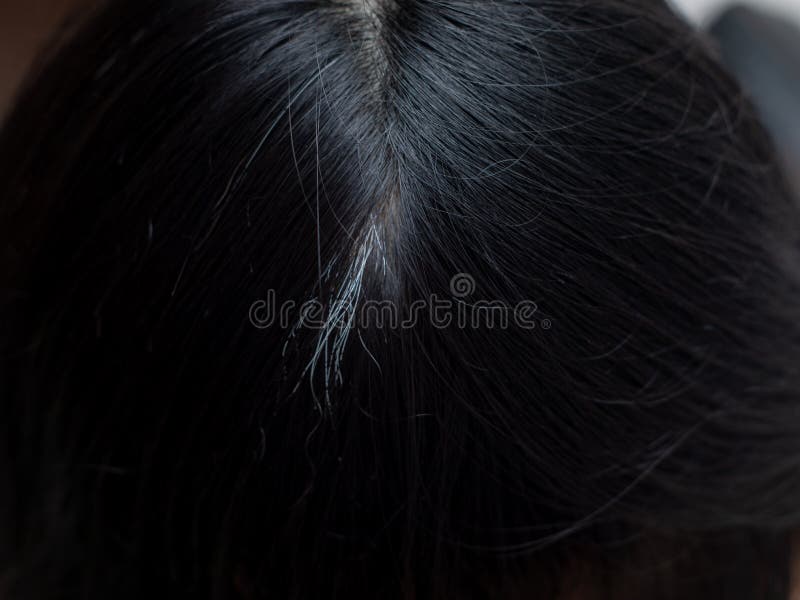 Young woman shows her white hair roots stock photo
