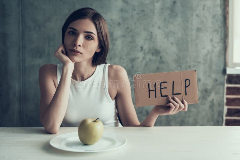 Young Woman with Sign Help and Eating One Apple. stock photo Young Woman with Sign Help and Eating One Apple. stock photo