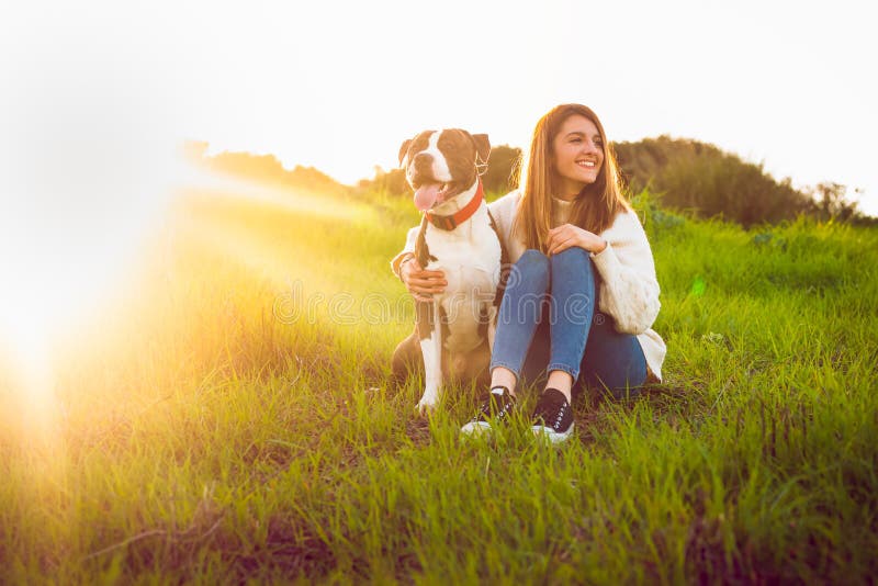Young woman sitting with American Staffordshire terrier royalty free stock photography Young woman sitting with American Staffordshire terrier royalty free stock photography