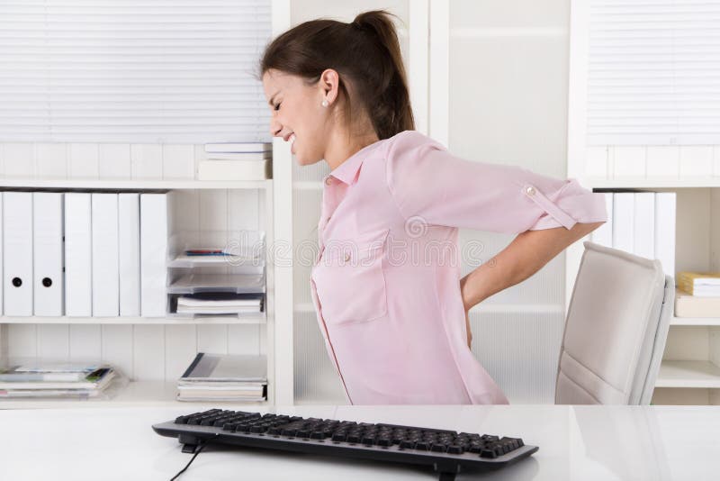 Mujer joven en rosas blusa dolor de espalda en oficina.