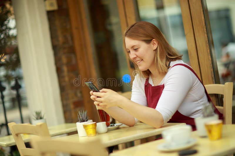 A Young Woman Sitting at a Coffee Shop Stock Photo - Image of message ...