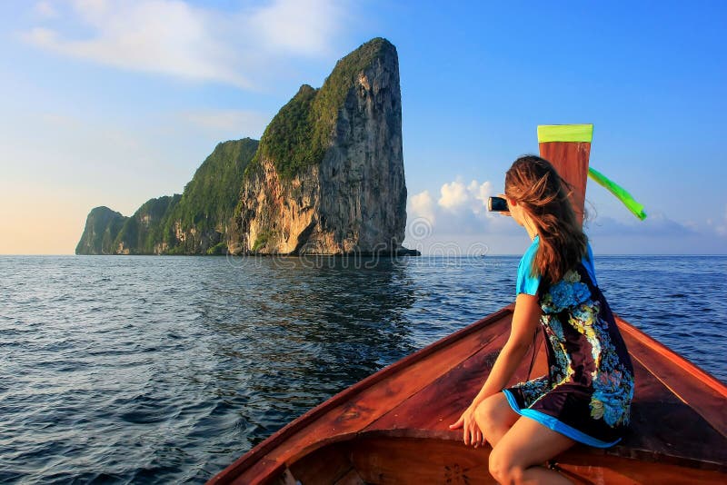 Young woman sitting in the front of a longtail boat going to Phi