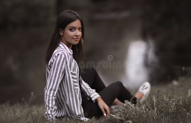 Young woman sitting near the river