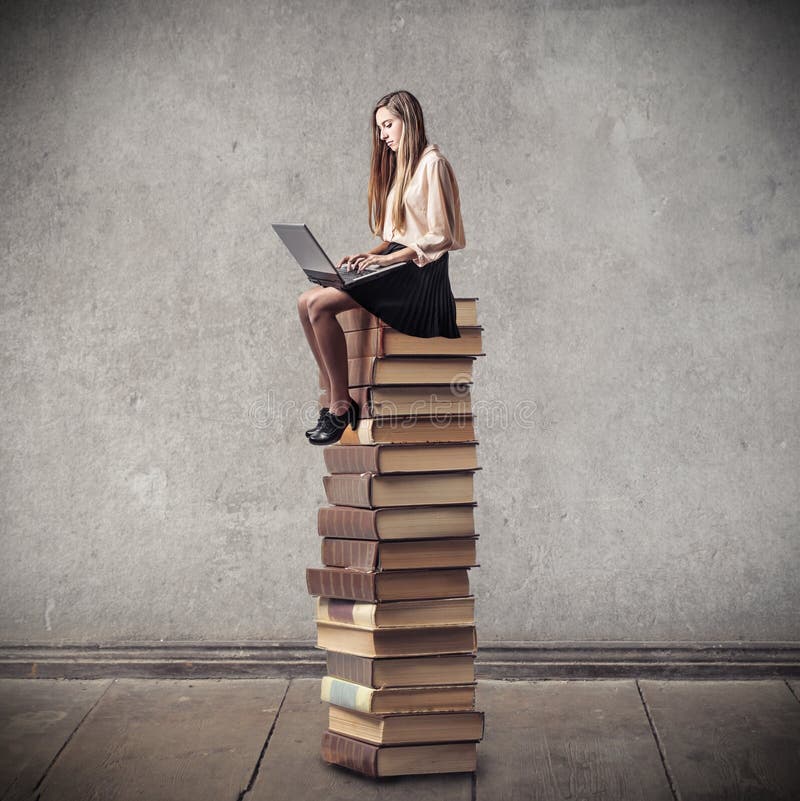 Young woman sitting on a pile of books