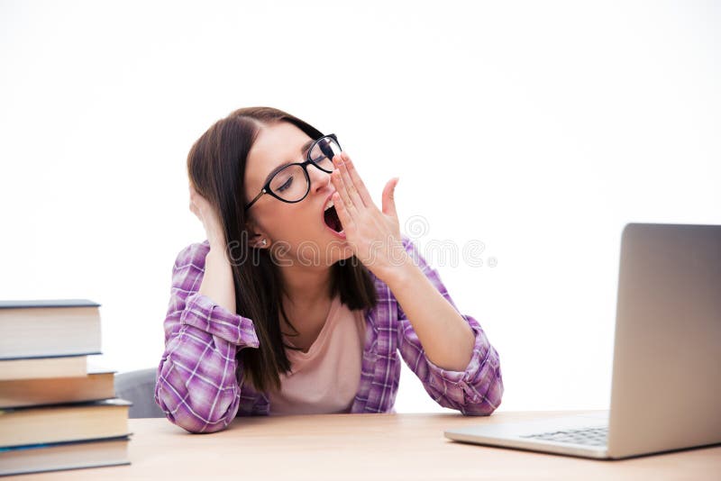 Young woman sitting at the table and yawning stock image Young woman sitting at the table and yawning stock image
