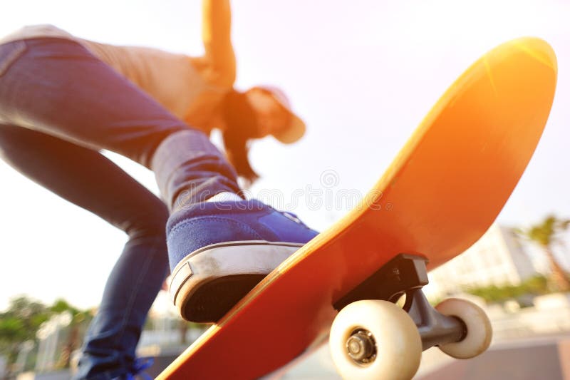 Young woman skateboarding at sunrise skatepark