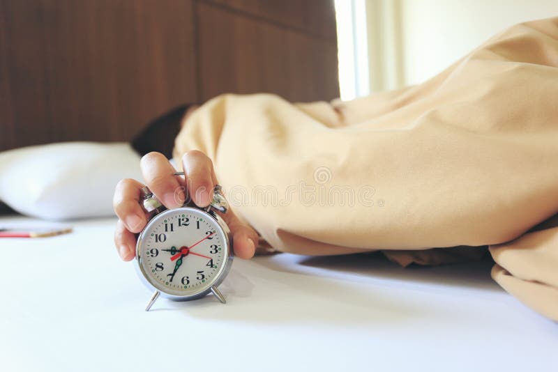 Young woman sleeping in the bedroom with Handle the alarm clock in the morning, Health concept stock photo Young woman sleeping in the bedroom with Handle the alarm clock in the morning, Health concept stock photo