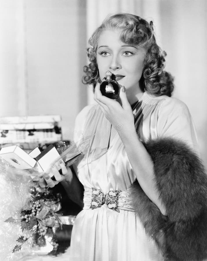 Young woman smelling perfume stock image
