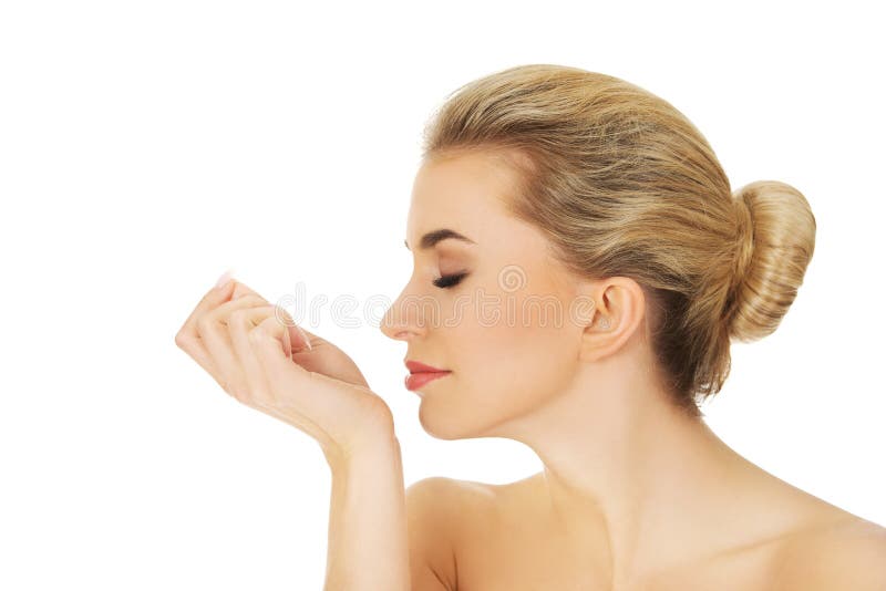 Young woman smelling perfume on her wrist. stock image