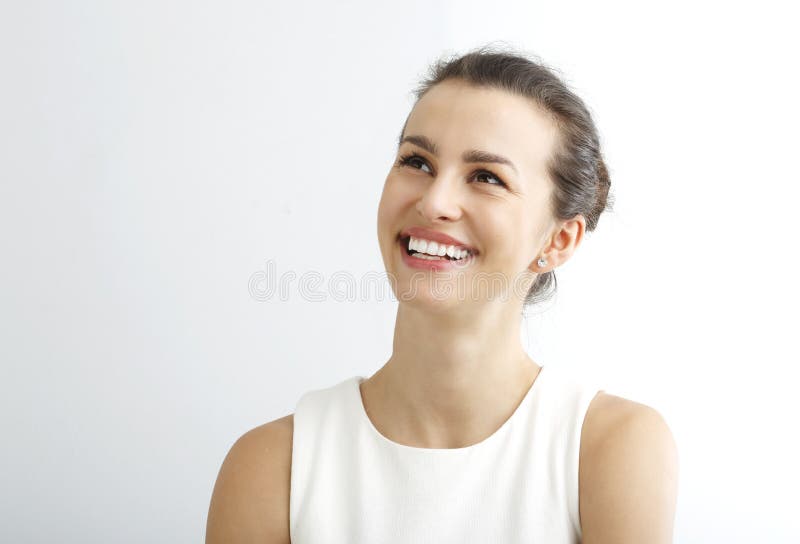 Beautiful young woman smiling and looking up against white background. Cut smiling stock images, royalty-free photos and pictures