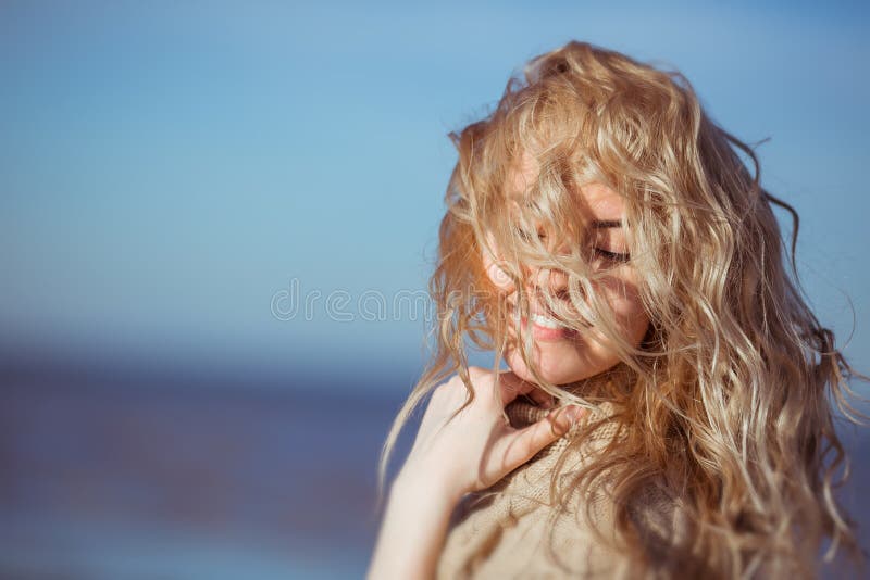 A young woman is smiling, her hair hanging down on her face stock photo A young woman is smiling, her hair hanging down on her face stock photo