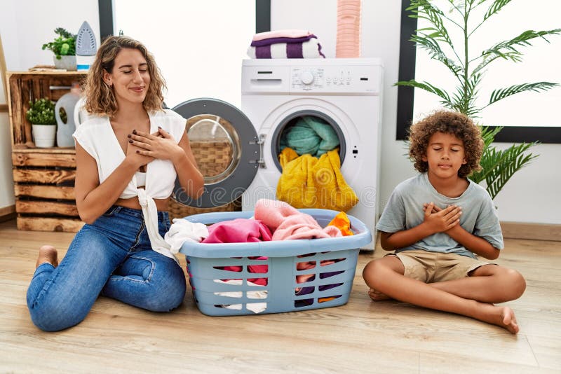 Young Woman and Son Putting Dirty Laundry into Washing Machine Smiling ...