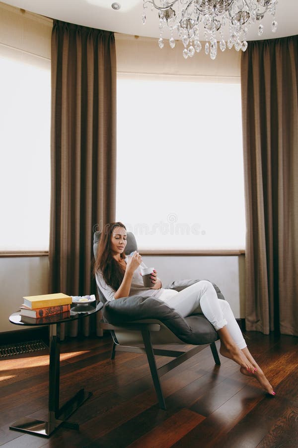 A young woman spends time at home, in the kitchen and in the roo royalty free stock image A young woman spends time at home, in the kitchen and in the roo royalty free stock image