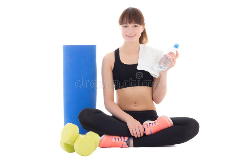 young woman in sports wear with bottle of water, mat and dumbbells isolated on white