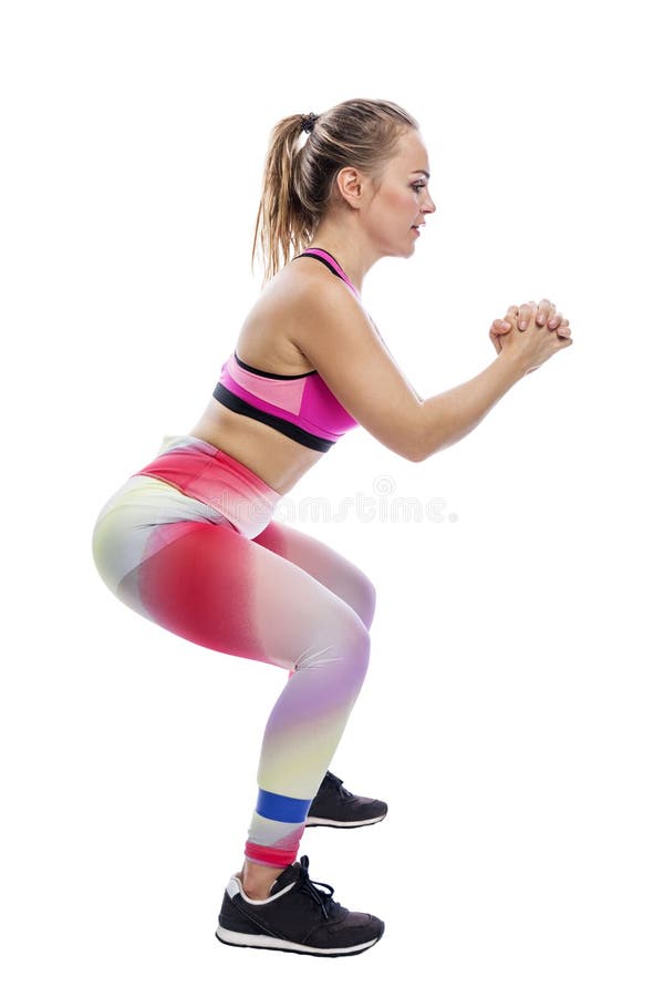 A Young Woman Squats with an Elastic Band on Her Legs. Smiling