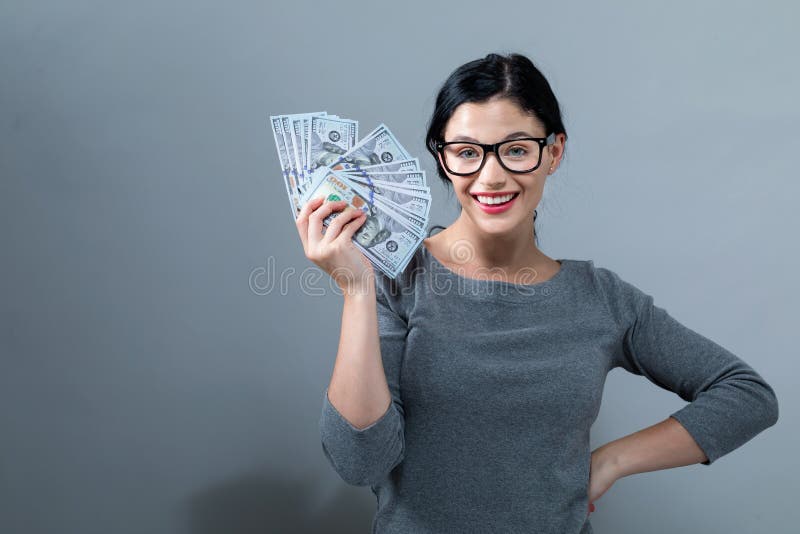 Young woman with a stack of cash USD