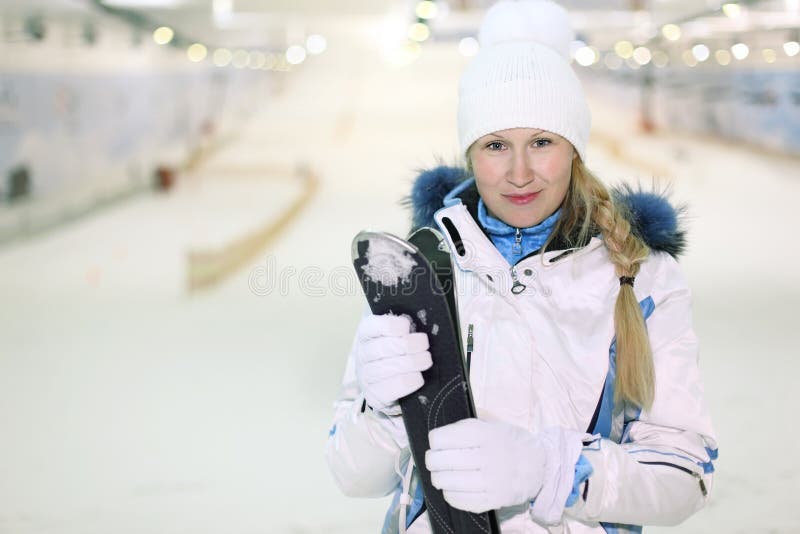 Young woman stand and keeps skis