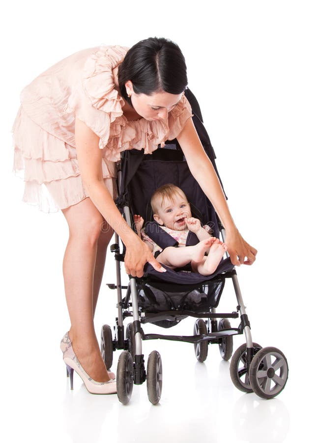 A young woman is standing near her child in a pram