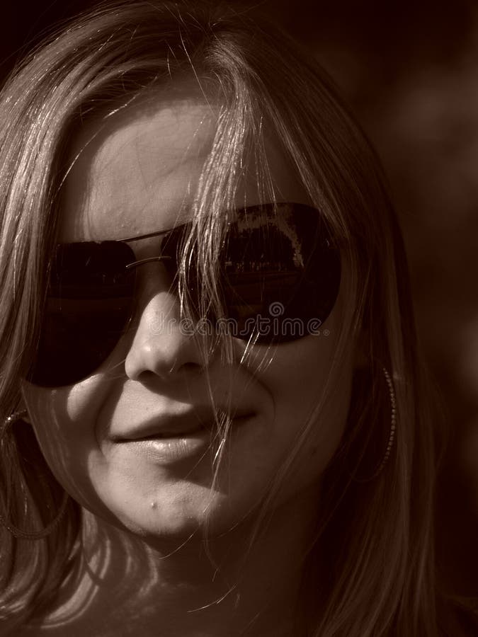 Young woman with sun glasses in sepia