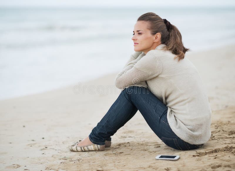 Download Young Woman In Sweater With Cell Phone Sitting On Lonely Beach Stock Image - Image of coast, clothes: 34522119