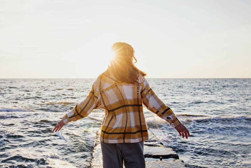 Young woman taken off the medical mask at the sunrise with warm sunlight