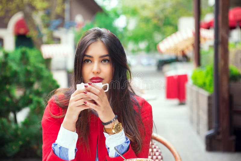 Young woman thinking holding coffee on a trendy cafe terrace stock image Young woman thinking holding coffee on a trendy cafe terrace stock image