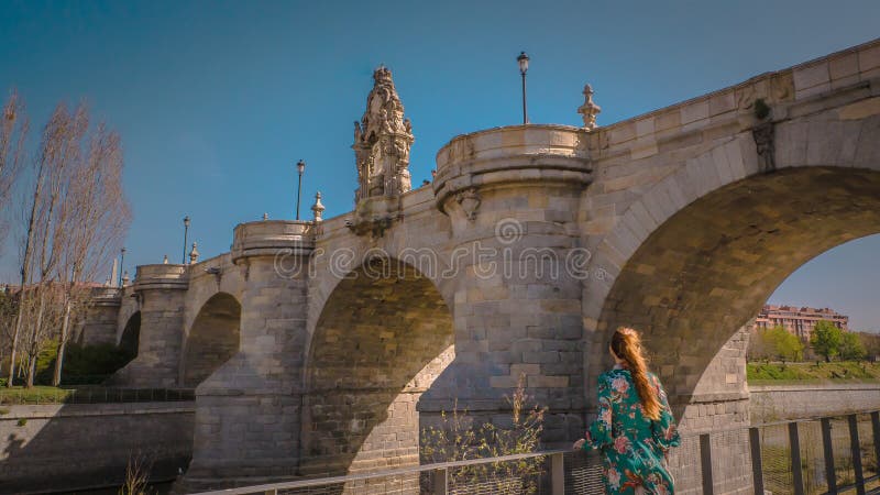 A young woman at Toledo medieval bridge at Madrid Rio park in Spain stock image A young woman at Toledo medieval bridge at Madrid Rio park in Spain stock image