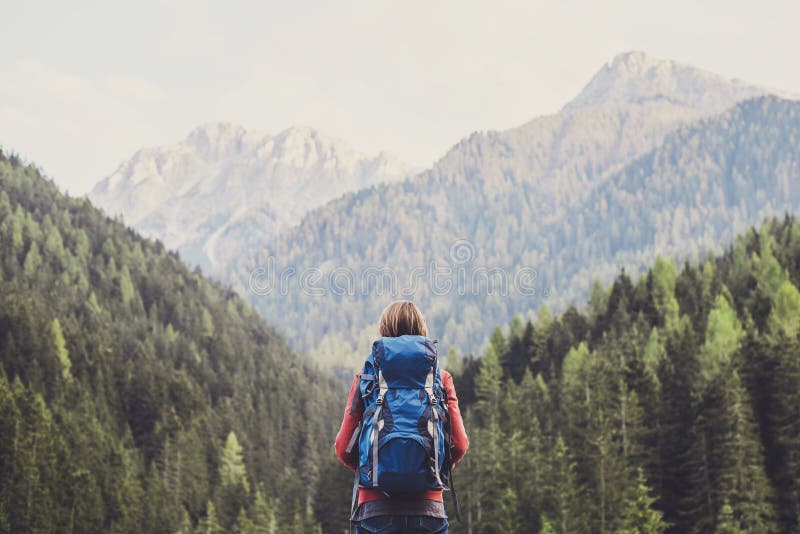 Young woman traveler in Alps mountains. Travel and active lifestyle concept