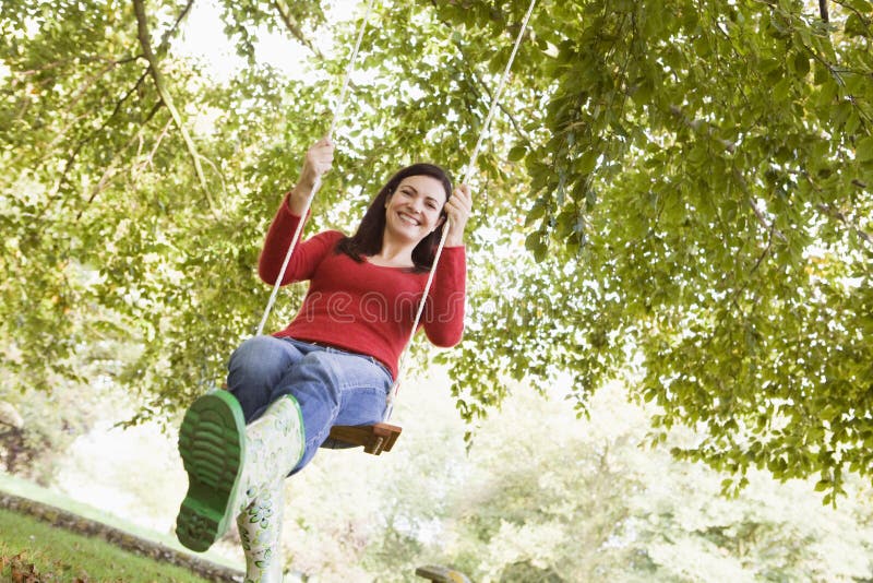 Young woman on tree swing