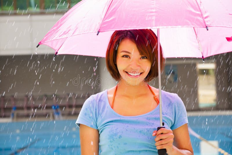 Young woman under pink umbrella stock image