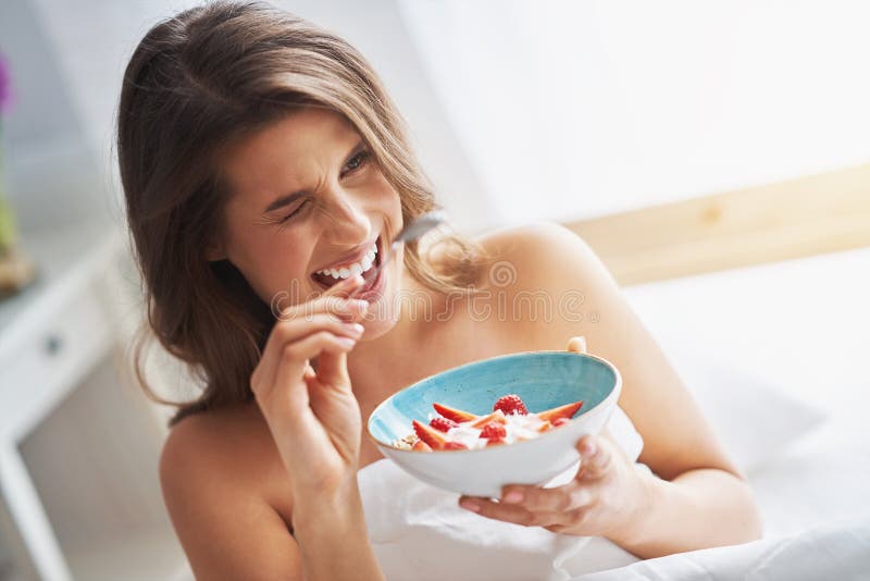 Portrait of young woman in underwear eating cereals