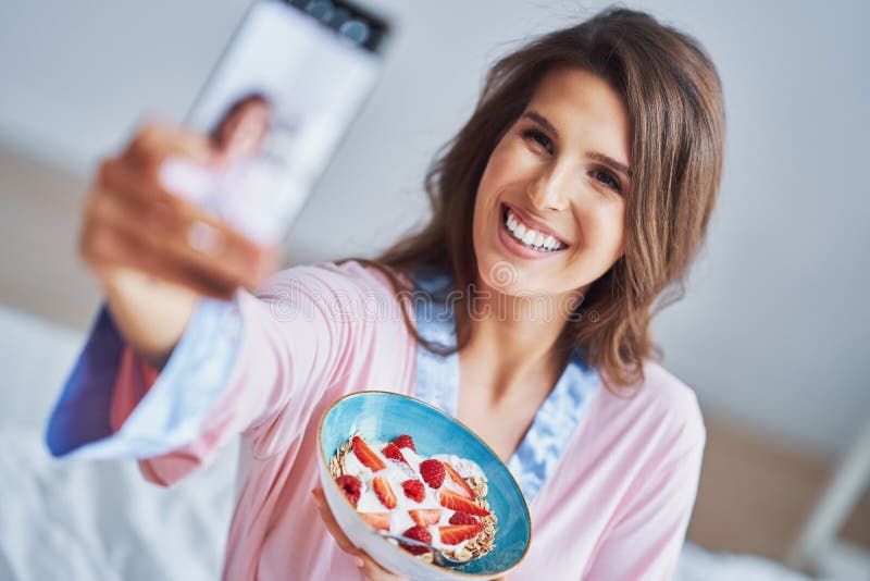 Portrait of young woman in underwear eating cereals